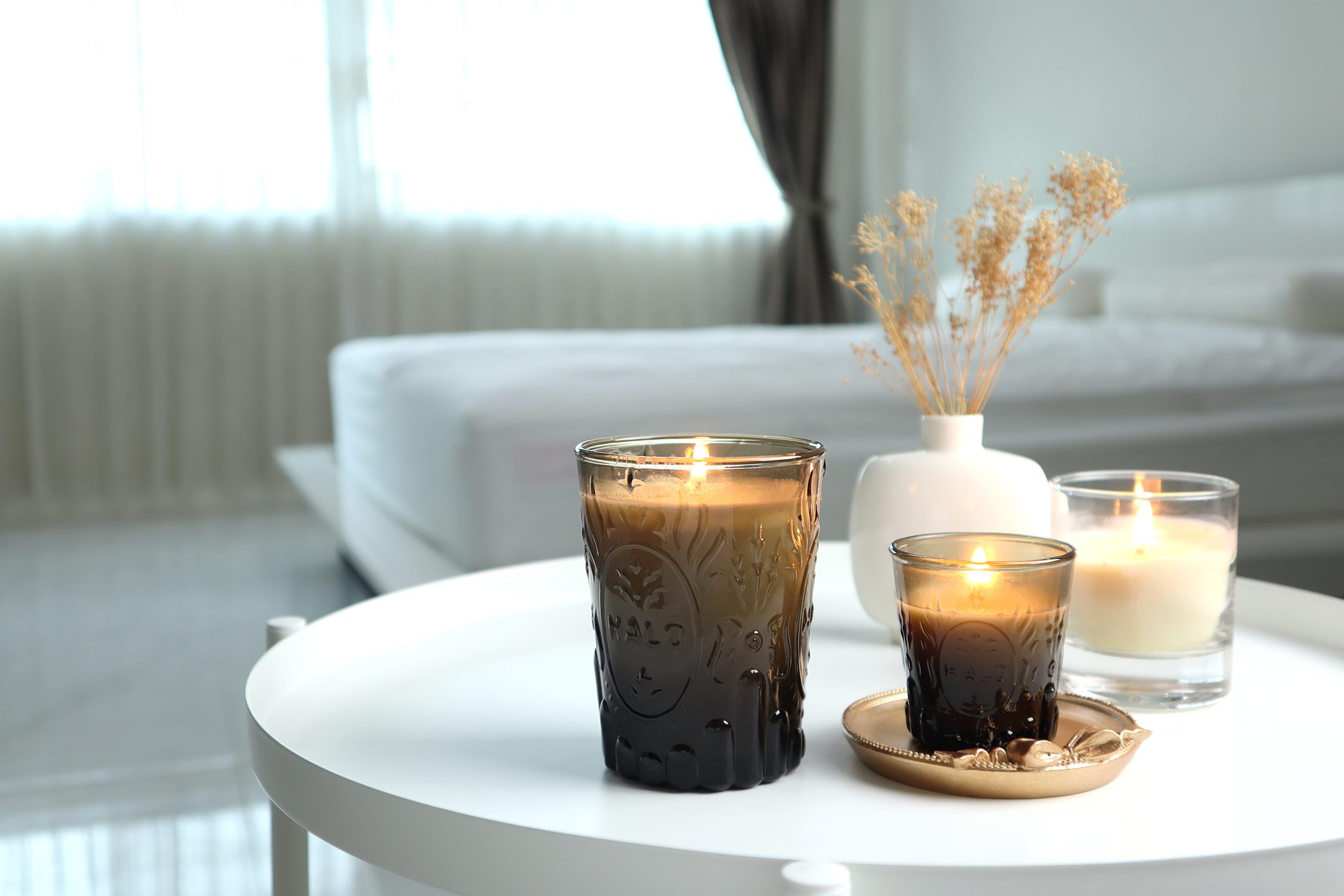 Candles on table in a cozy bedroom.