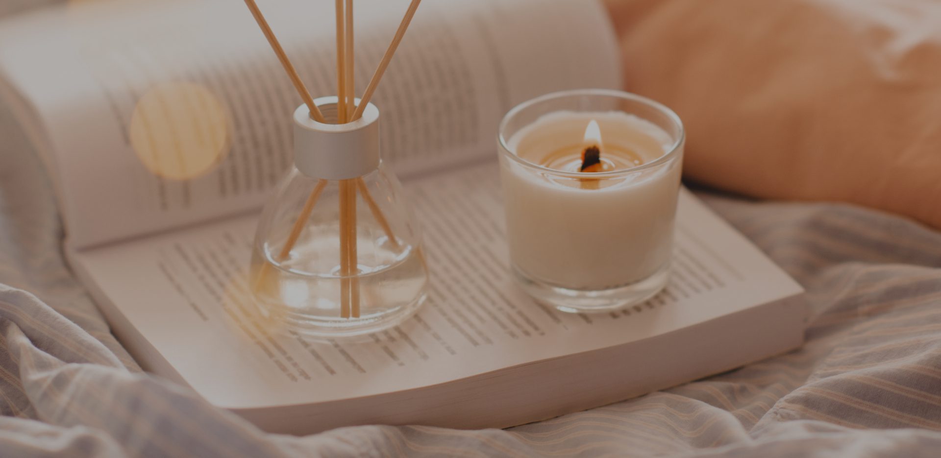 Candle and diffuser on open book.