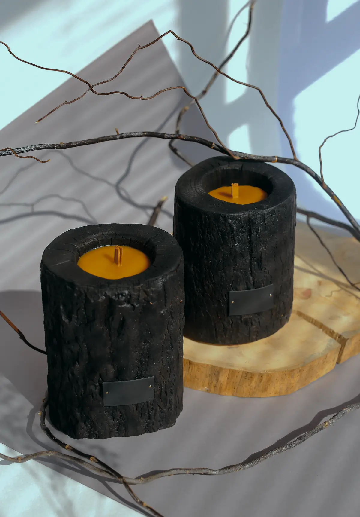 Charred log candle holders with yellow candles